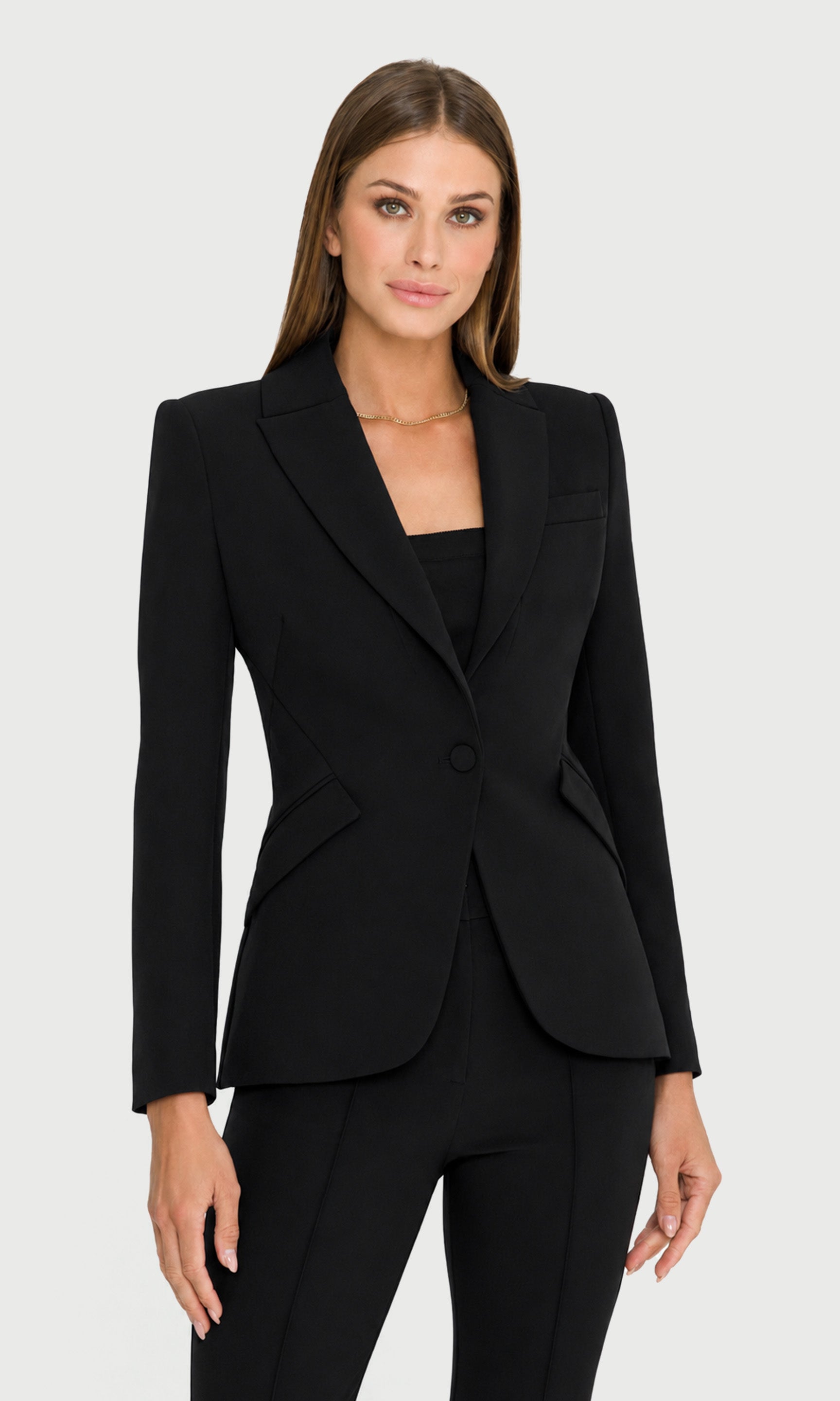 Woman wearing a black suit jacket on a white background