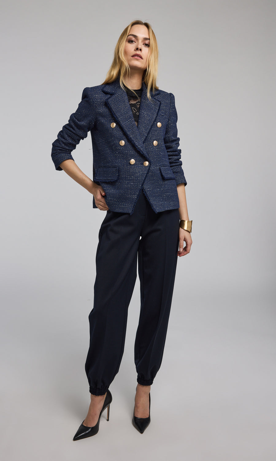 The image features a navy tweed blazer with striking gold buttons, exemplifying classic fashion elegance.