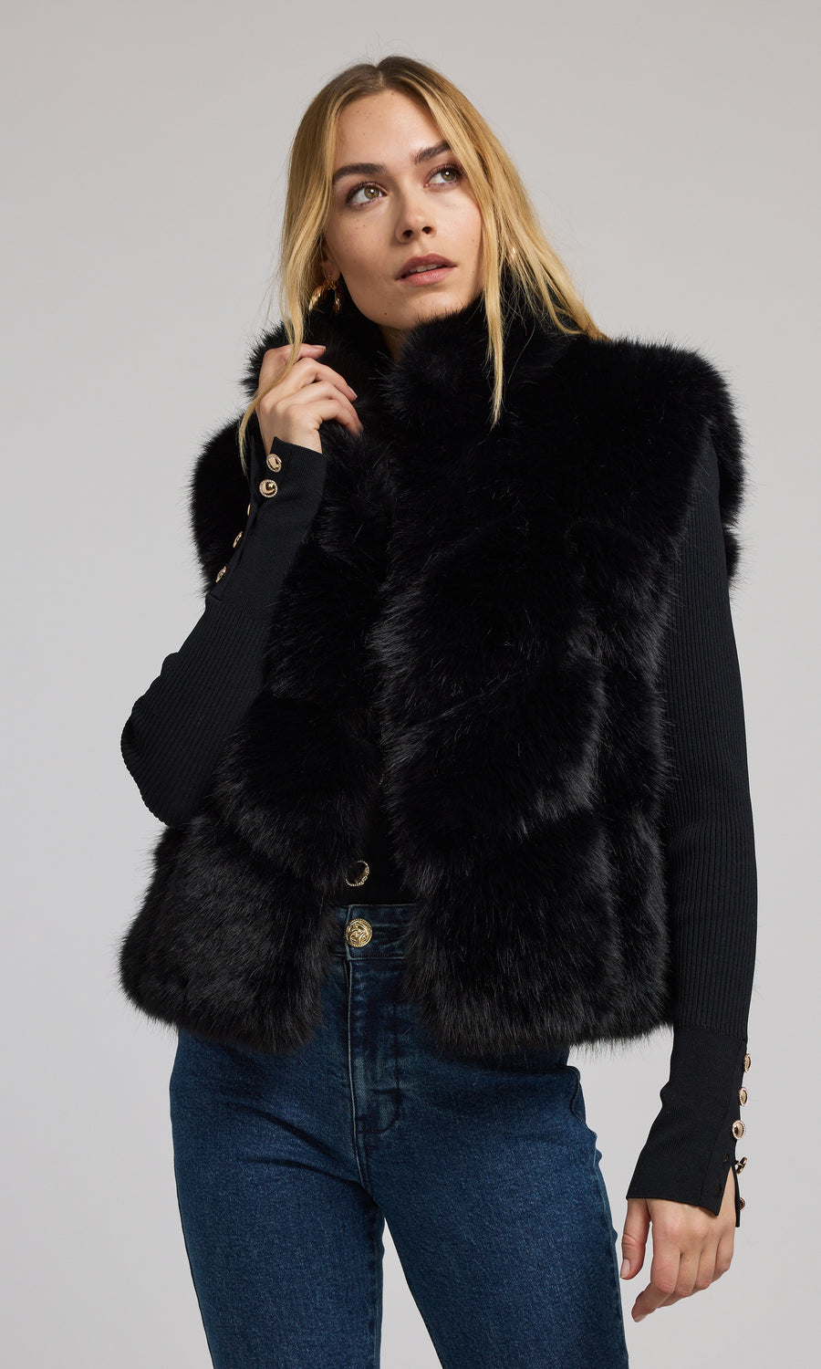 A fashionable black faux fur vest, designed for warmth and style, ideal for enhancing any ensemble with its plush texture.