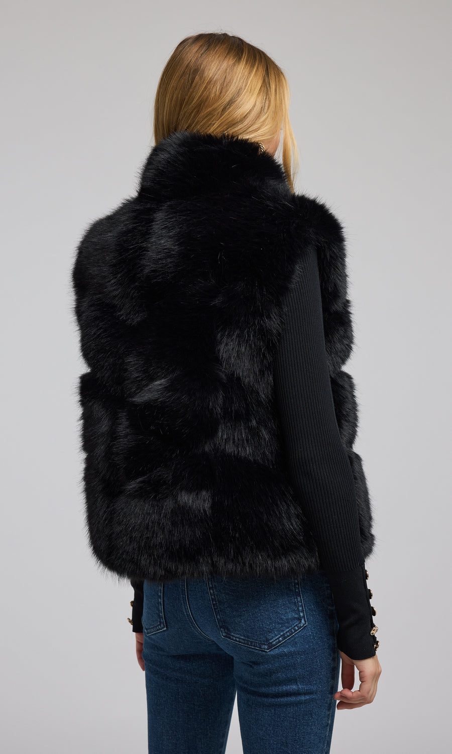 A fashionable black faux fur vest, designed for warmth and style, ideal for enhancing any ensemble with its plush texture.