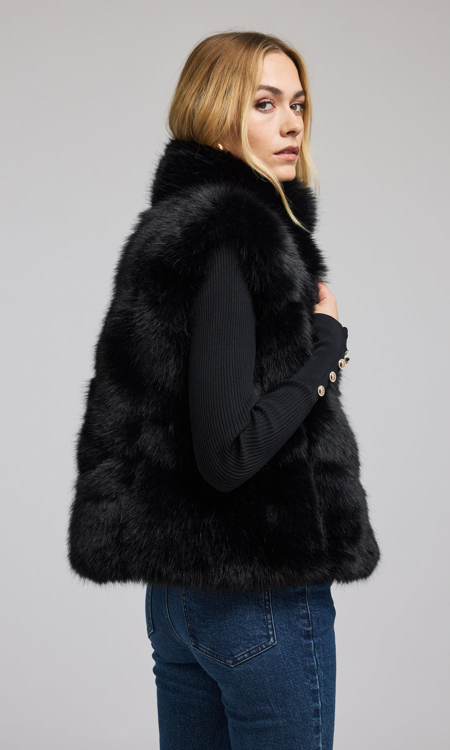 A fashionable black faux fur vest, designed for warmth and style, ideal for enhancing any ensemble with its plush texture.