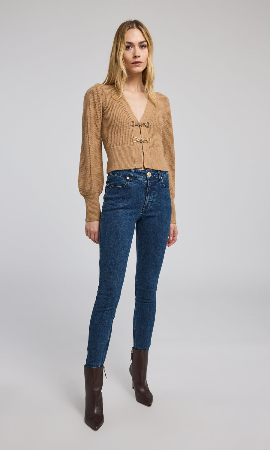 This cropped camel cardigan features a soft, ribbed knit texture, offering both comfort and a chic look for various outfits.