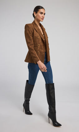 A model showcases a stylish brown suede blazer jacket, highlighting its texture and elegant design. 