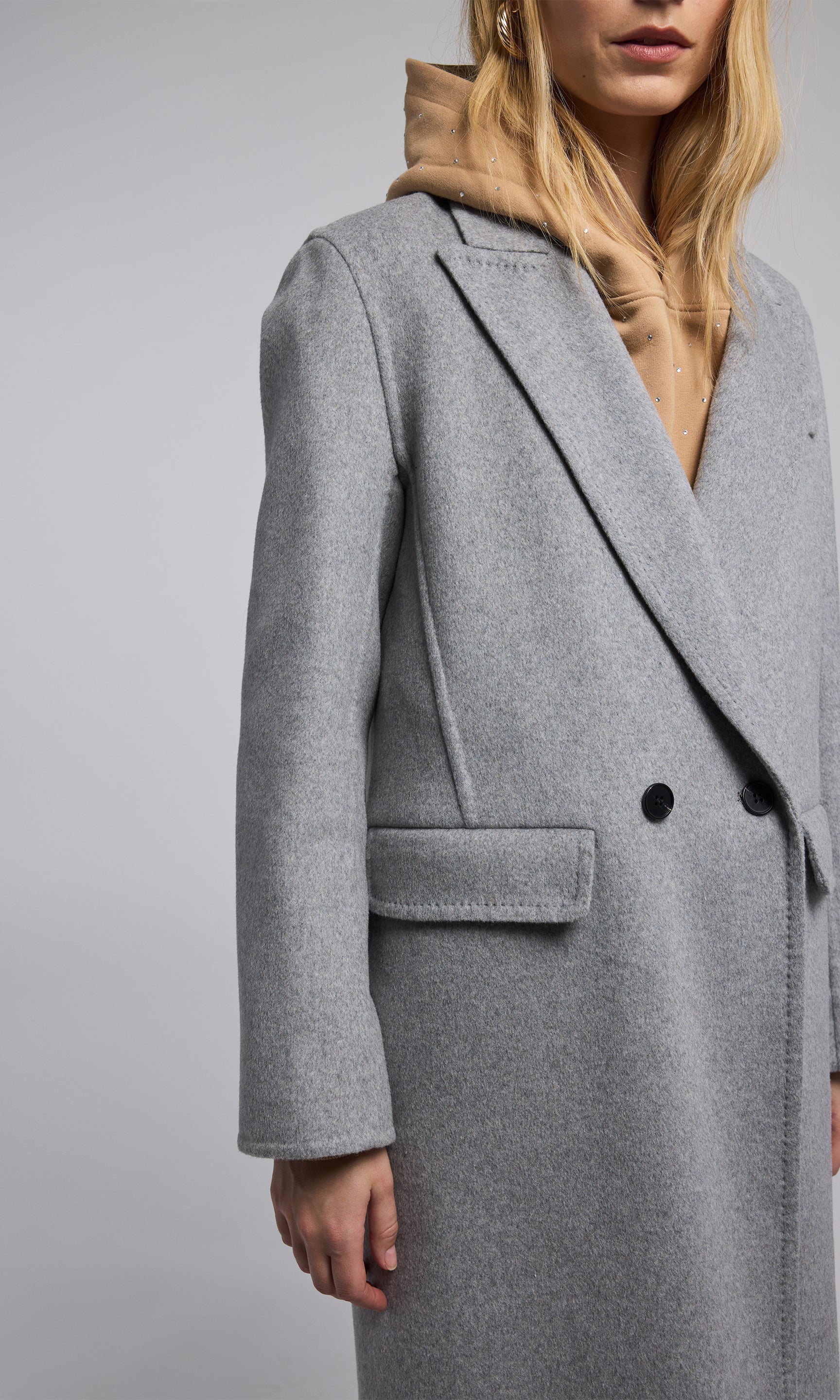 A light grey wool coat, elegantly designed, showcasing its soft texture and sophisticated style. 