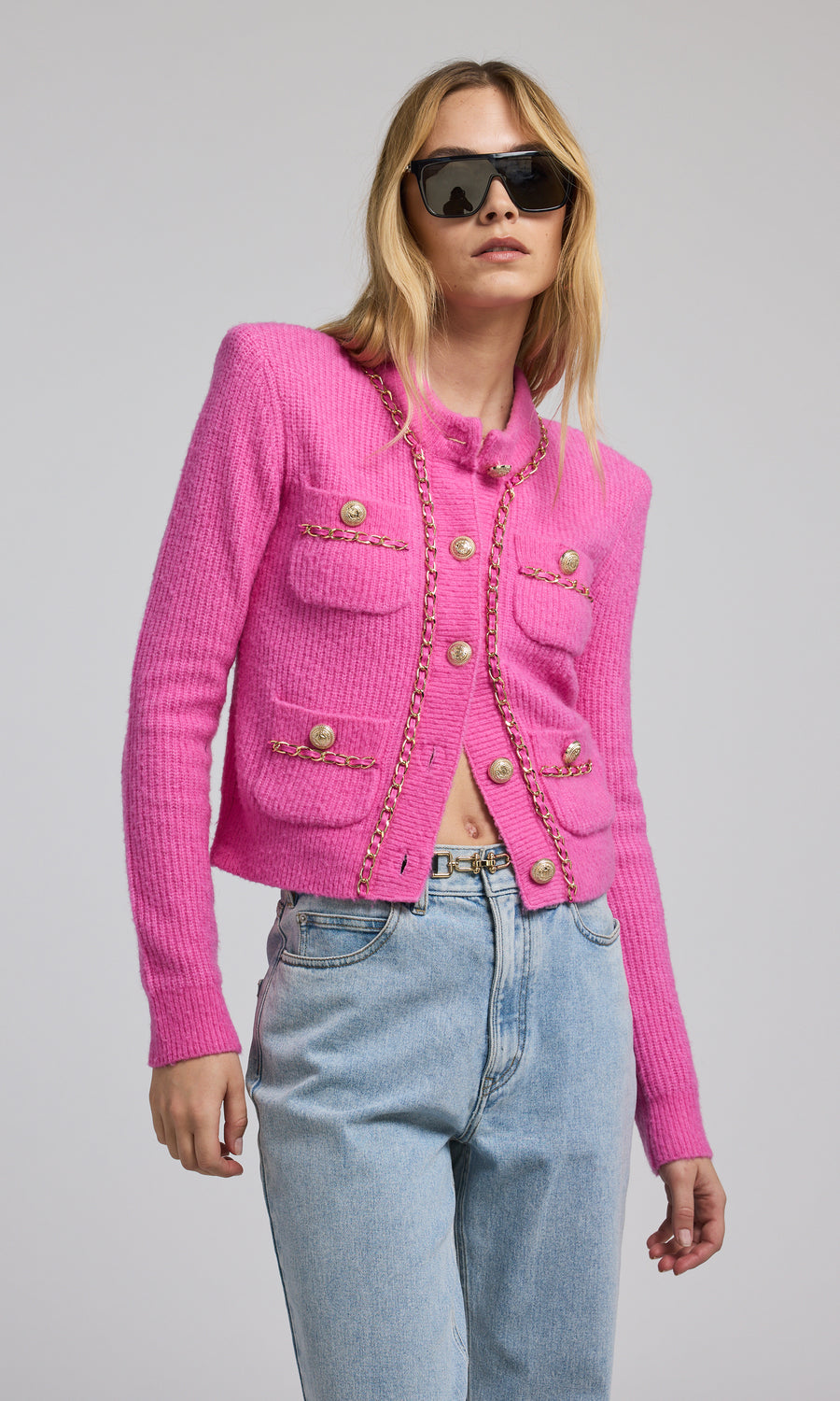 A pink chain cardigan featuring a buttoned front, showcasing a stylish and cozy design suitable for various occasions.