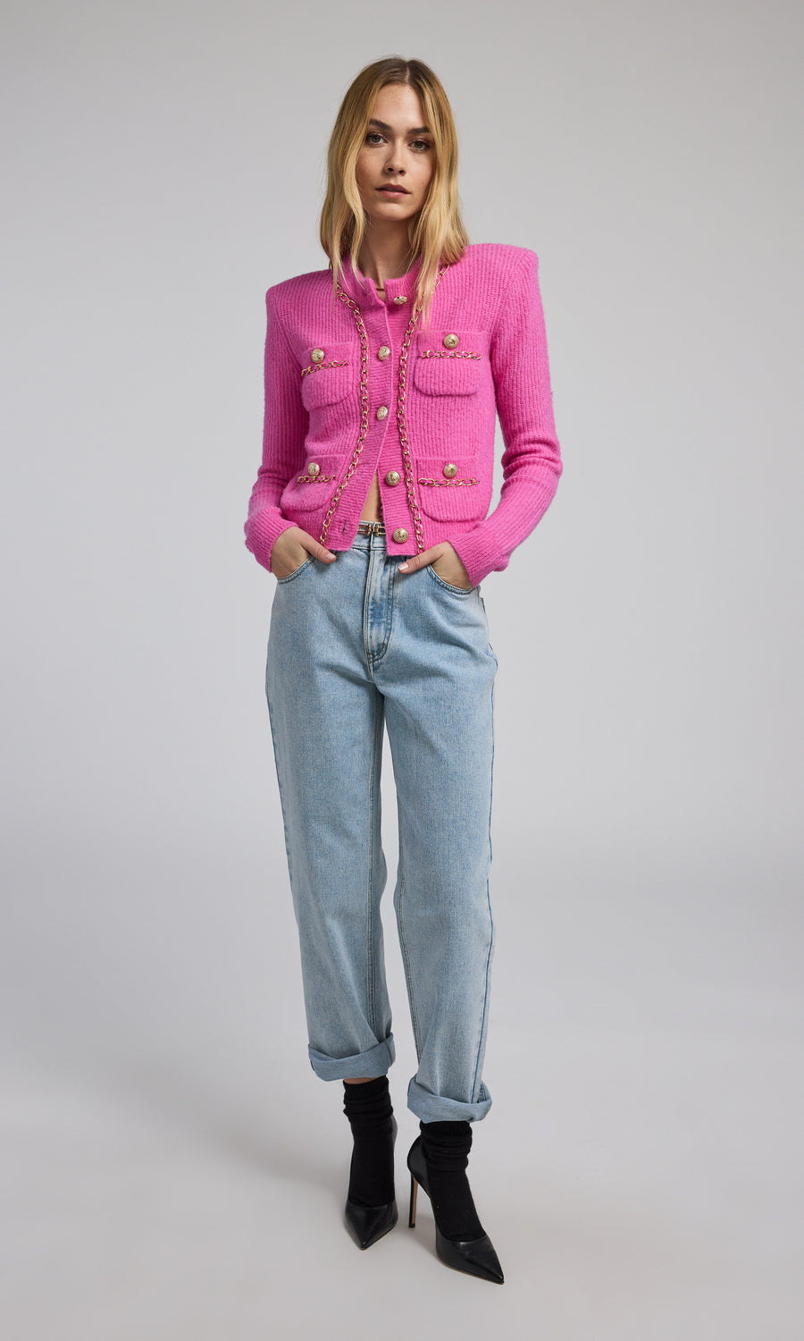 A pink chain cardigan featuring a buttoned front, showcasing a stylish and cozy design suitable for various occasions.