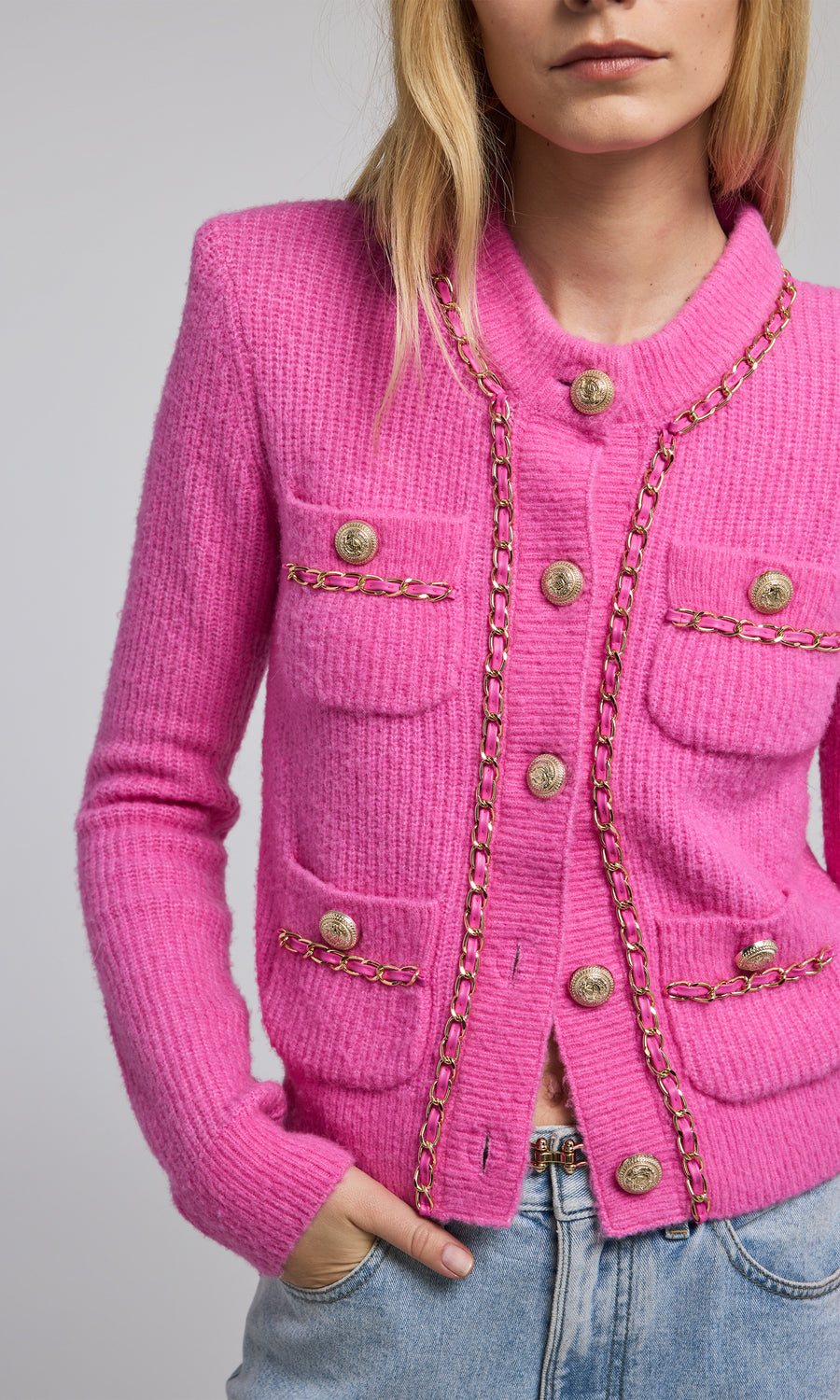 A pink chain cardigan featuring a buttoned front, showcasing a stylish and cozy design suitable for various occasions.