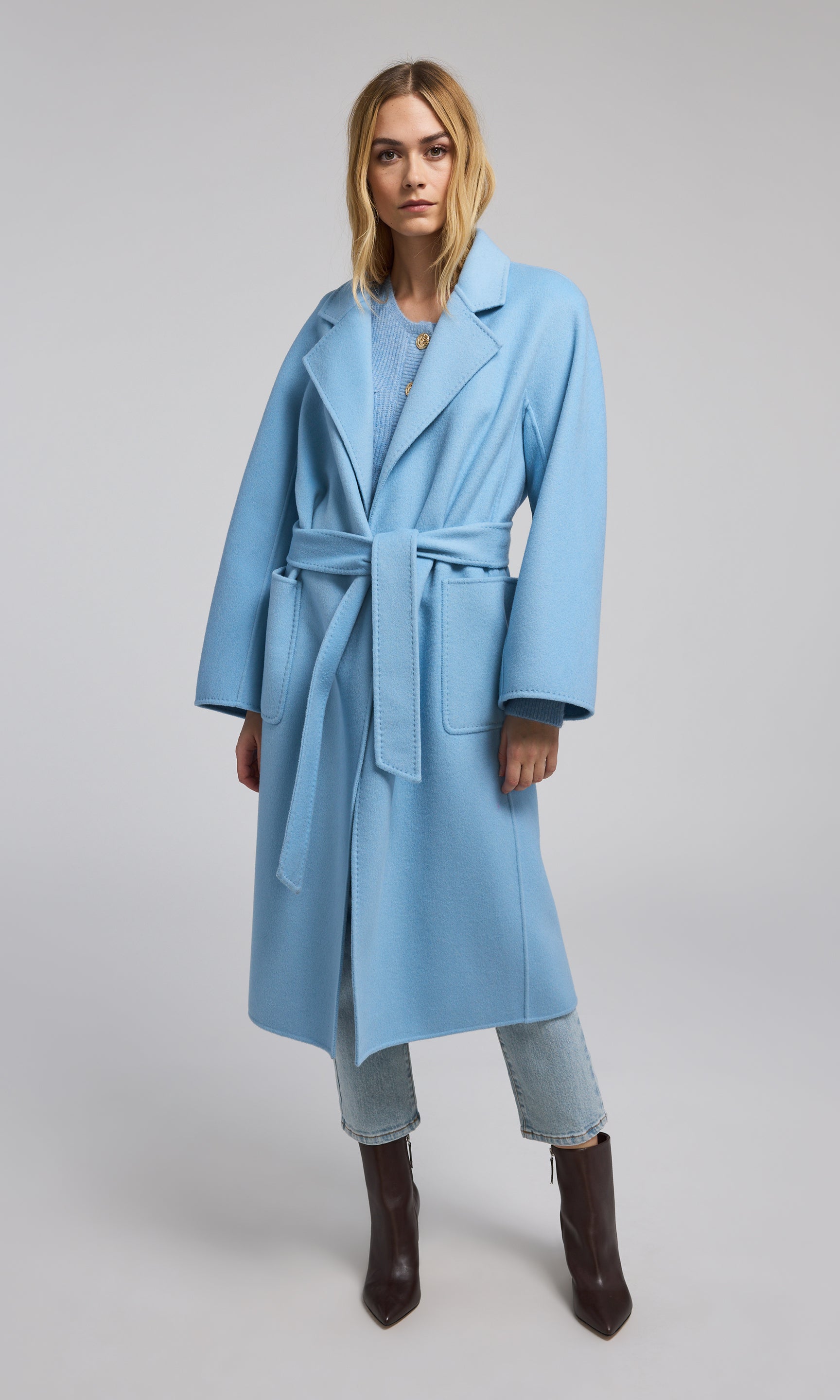 A fashionable blue wool coat adorned with a belt, perfect for adding a touch of style and warmth to any outfit.