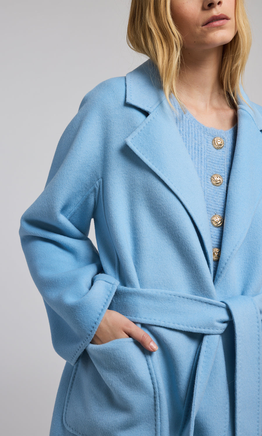 A fashionable blue wool coat adorned with a belt, perfect for adding a touch of style and warmth to any outfit.