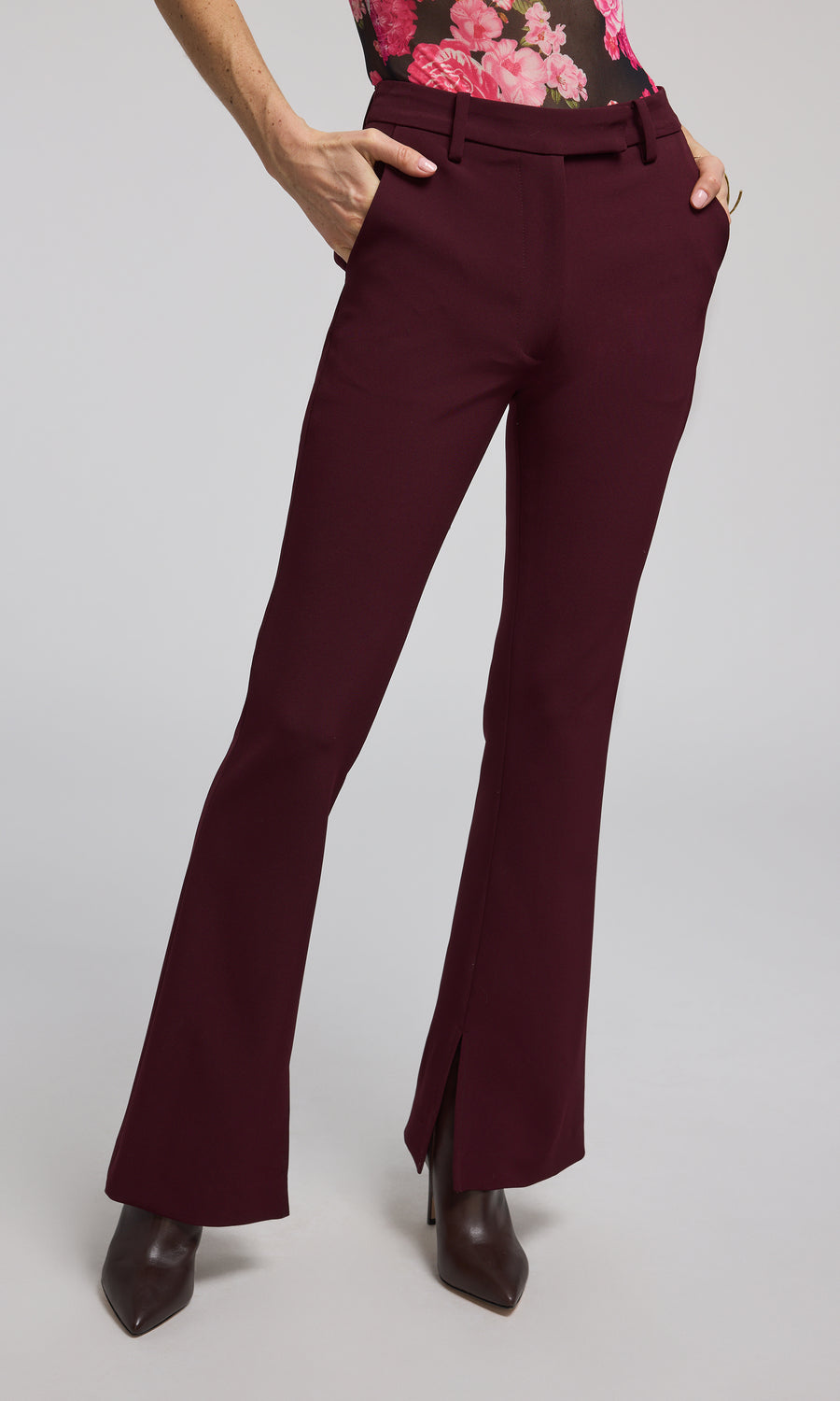 The image features a woman in chic burgundy Malbec crepe pants, highlighting her fashionable attire.