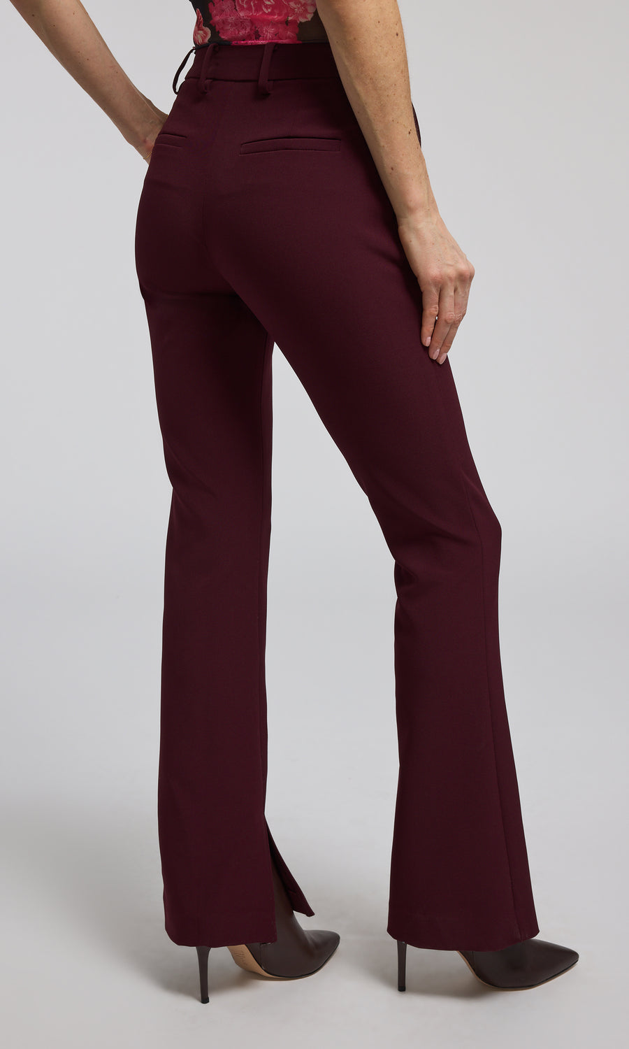 The image features a woman in chic burgundy Malbec crepe pants, highlighting her fashionable attire.