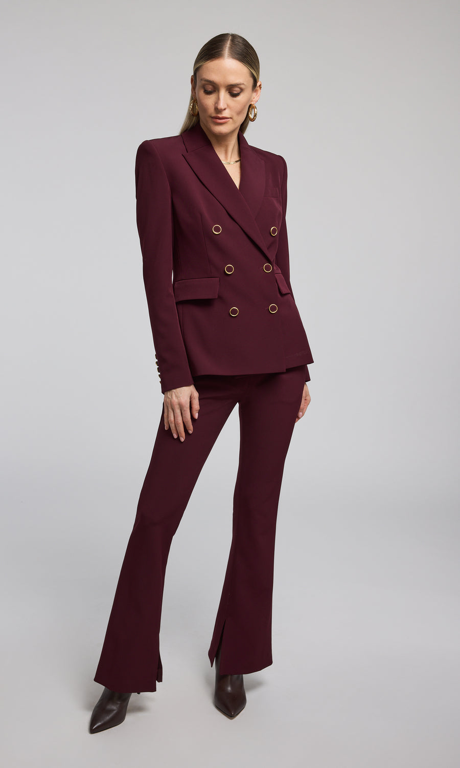 The image features a woman in chic burgundy Malbec crepe pants, highlighting her fashionable attire.