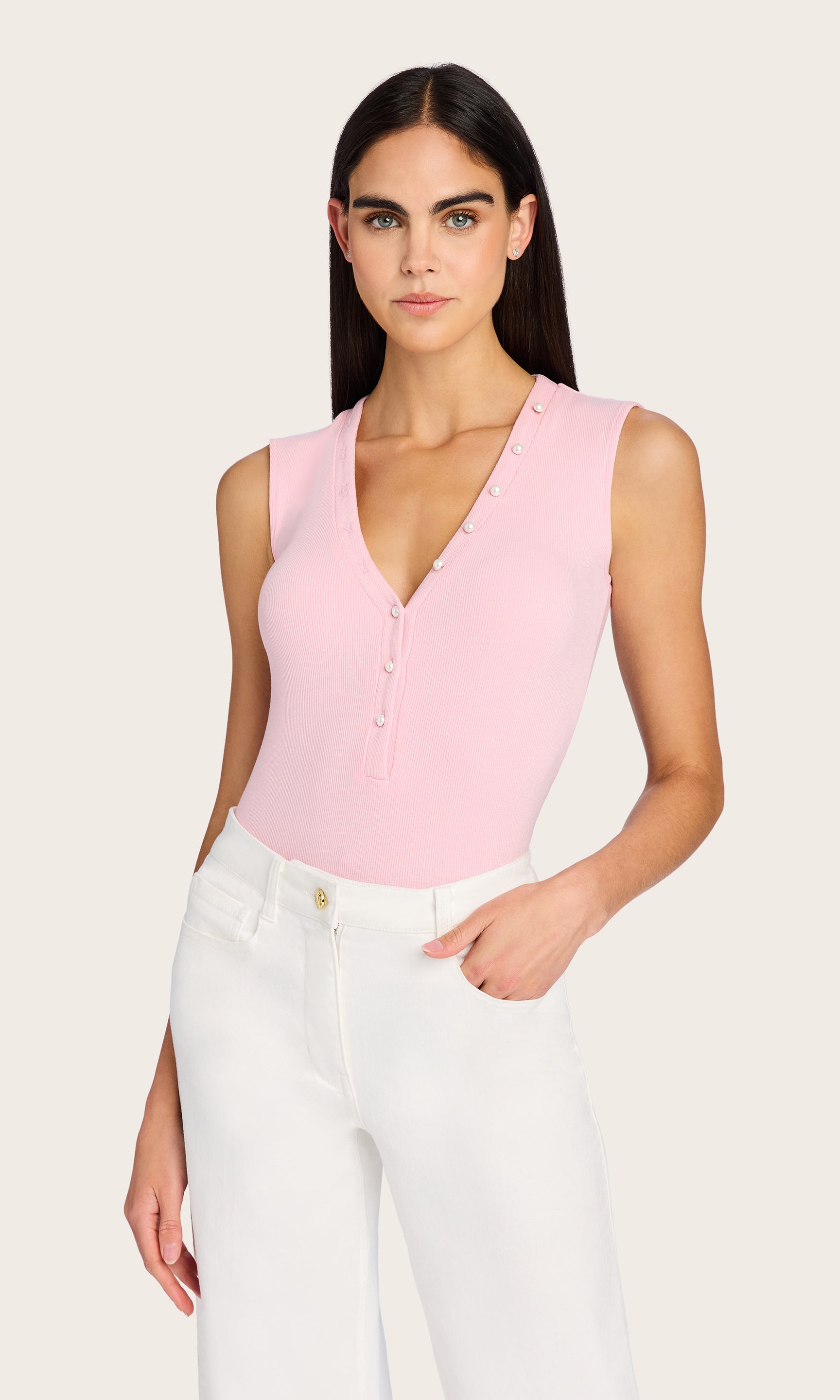 Front view of the Zoelle Rib Tank in pink, styled with white trousers and highlighting the pearl buttons and flattering neckline.