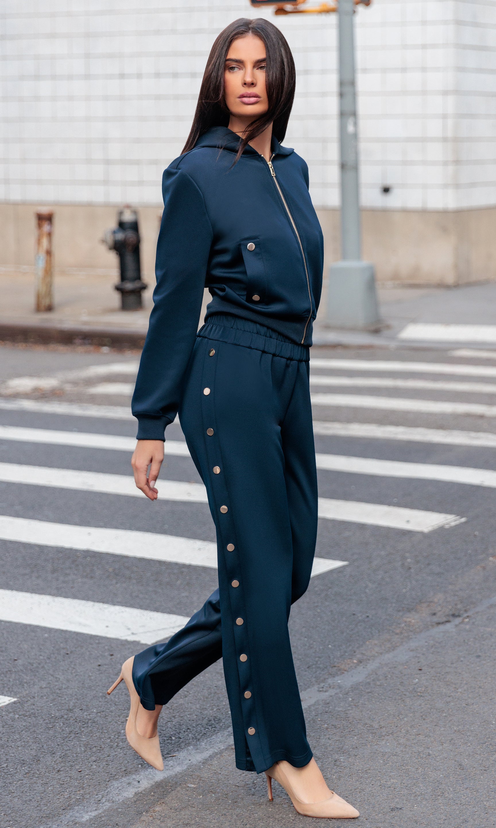 Woman in a teal outfit standing on a city street