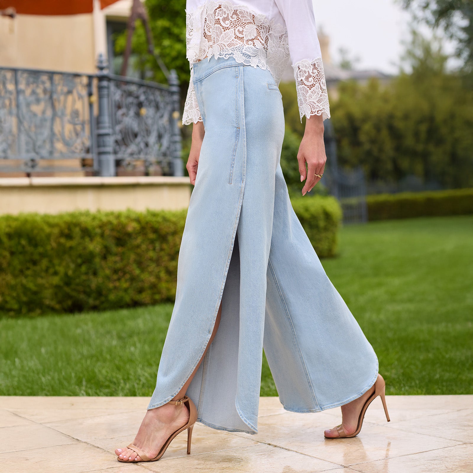 zoomed in image of model wearing the Keiko Jeans showcasing the side slit on the leg, paired with a white top and brown heels
