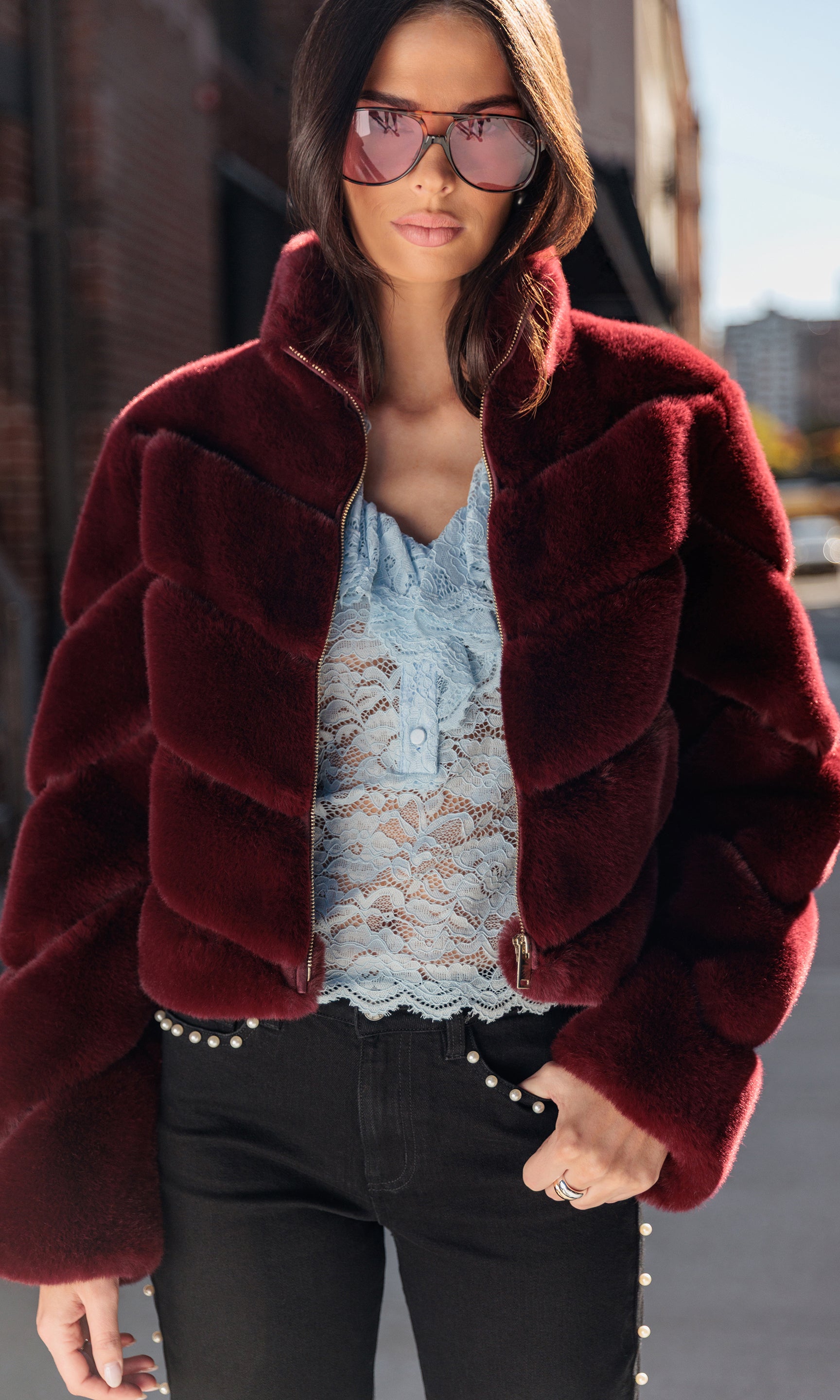 Woman wearing a red fur coat with a blurred background