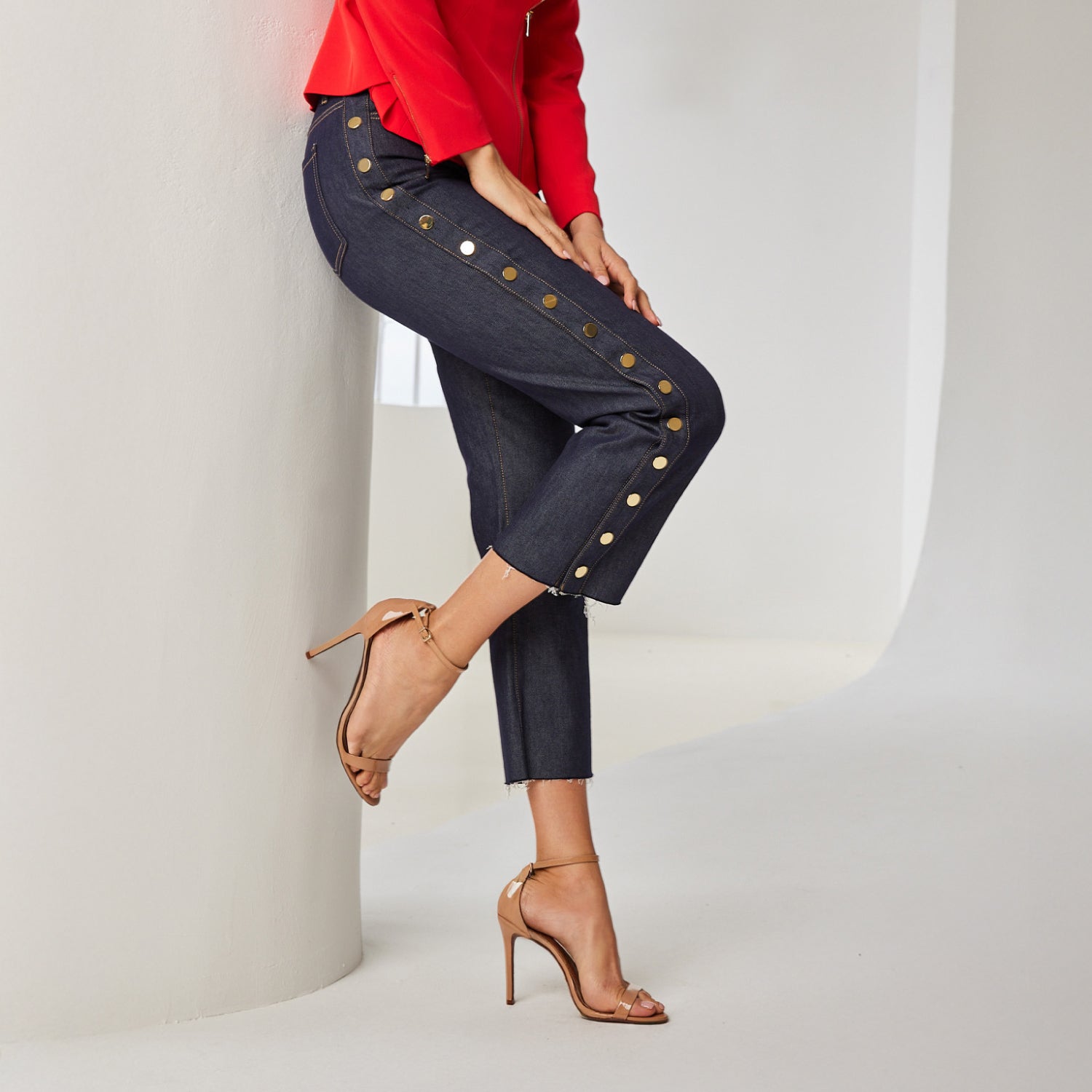 Dark denim with sheet, gold covered buttons running down side of dark wash denim jeans.