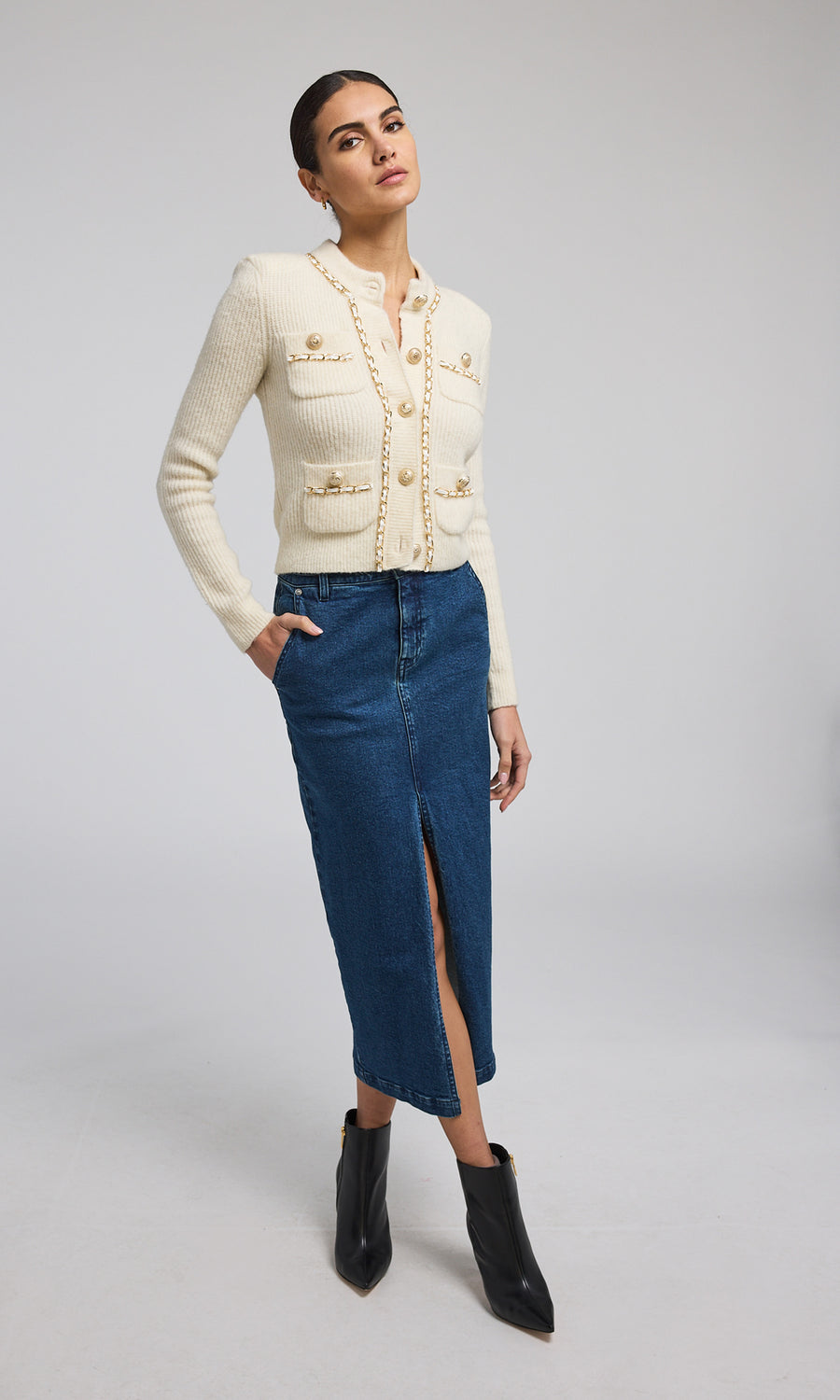 A buttoned front ivory chain cardigan, exemplifying warmth and elegance, perfect for layering in cooler weather.