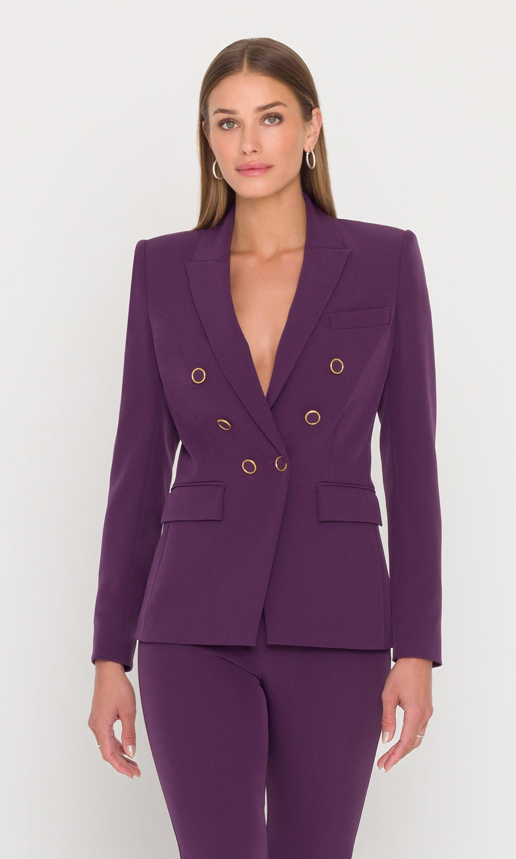 Model wears eggplant blazer with gold buttons.