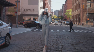 two models in a city street showing off different colored ski outfits