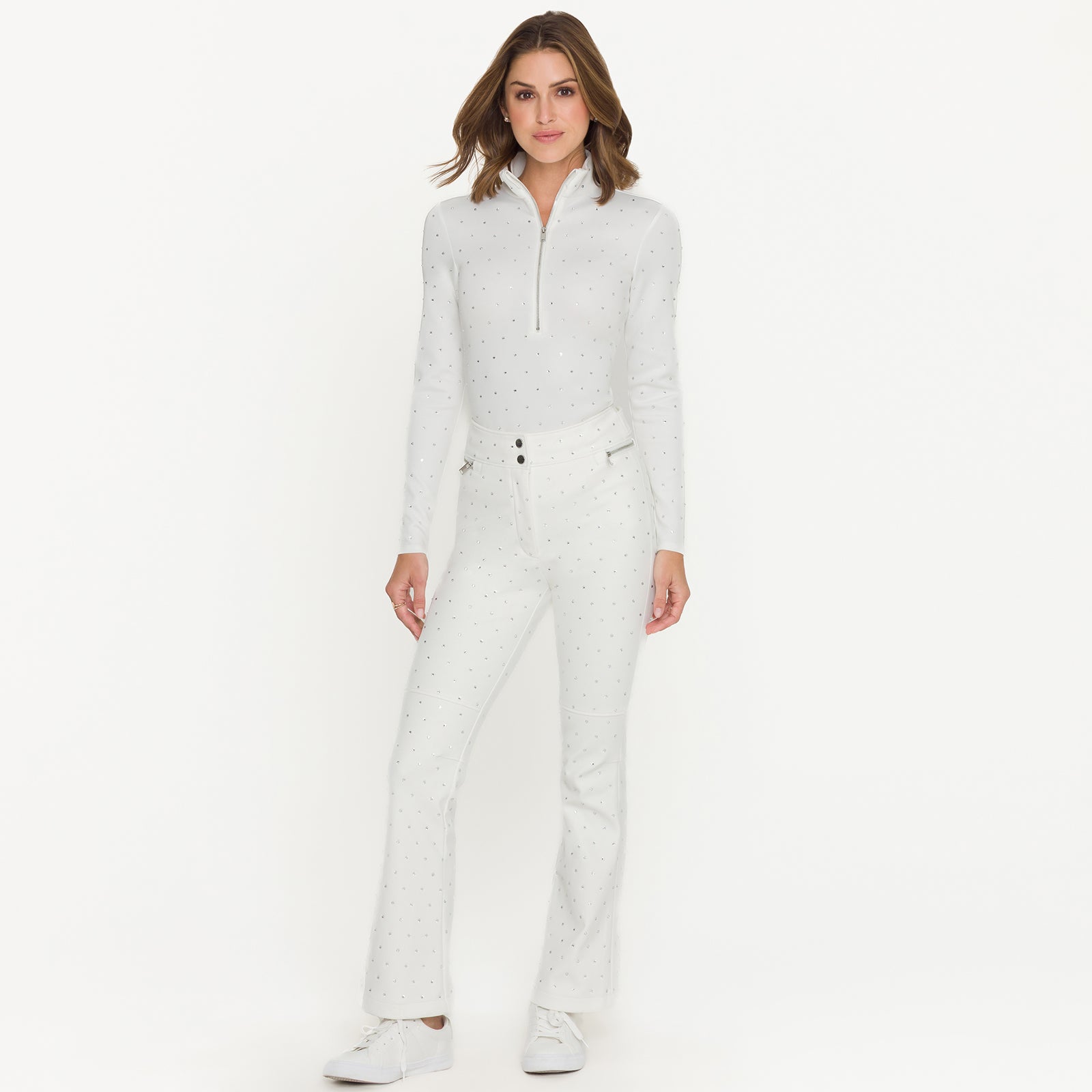 Woman wearing a white ski outfit with crystal embellishments on a white background